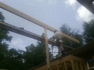 Carpenter setting a ridge beam over a new addition frame — Ice Dam Removal by Roofing Brothers in Longmont