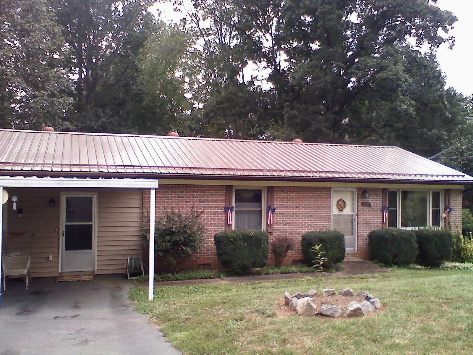 Bronze metal roof and carport on a brick ranch home — Roof Repair work by our crew in Longmont